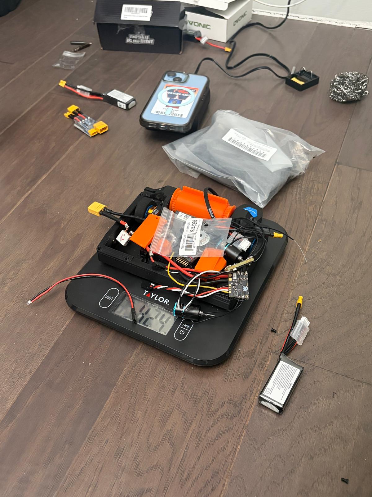 the chassis, drum and loose electronics on a kitchen scale reading 424 g