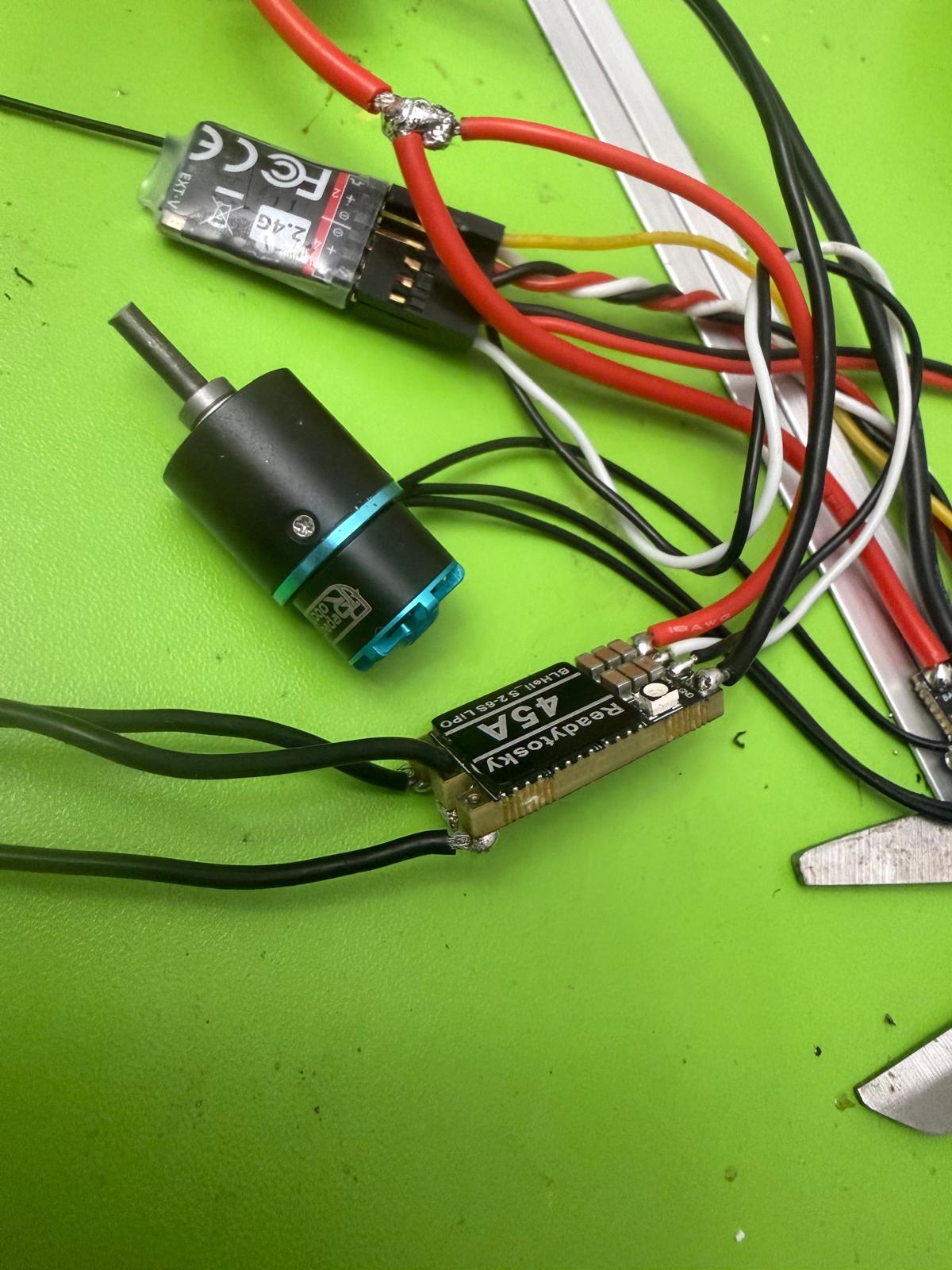 the 45 a weapon esc soldered, a 1106 motor, the er4 receiver and spliced power leads