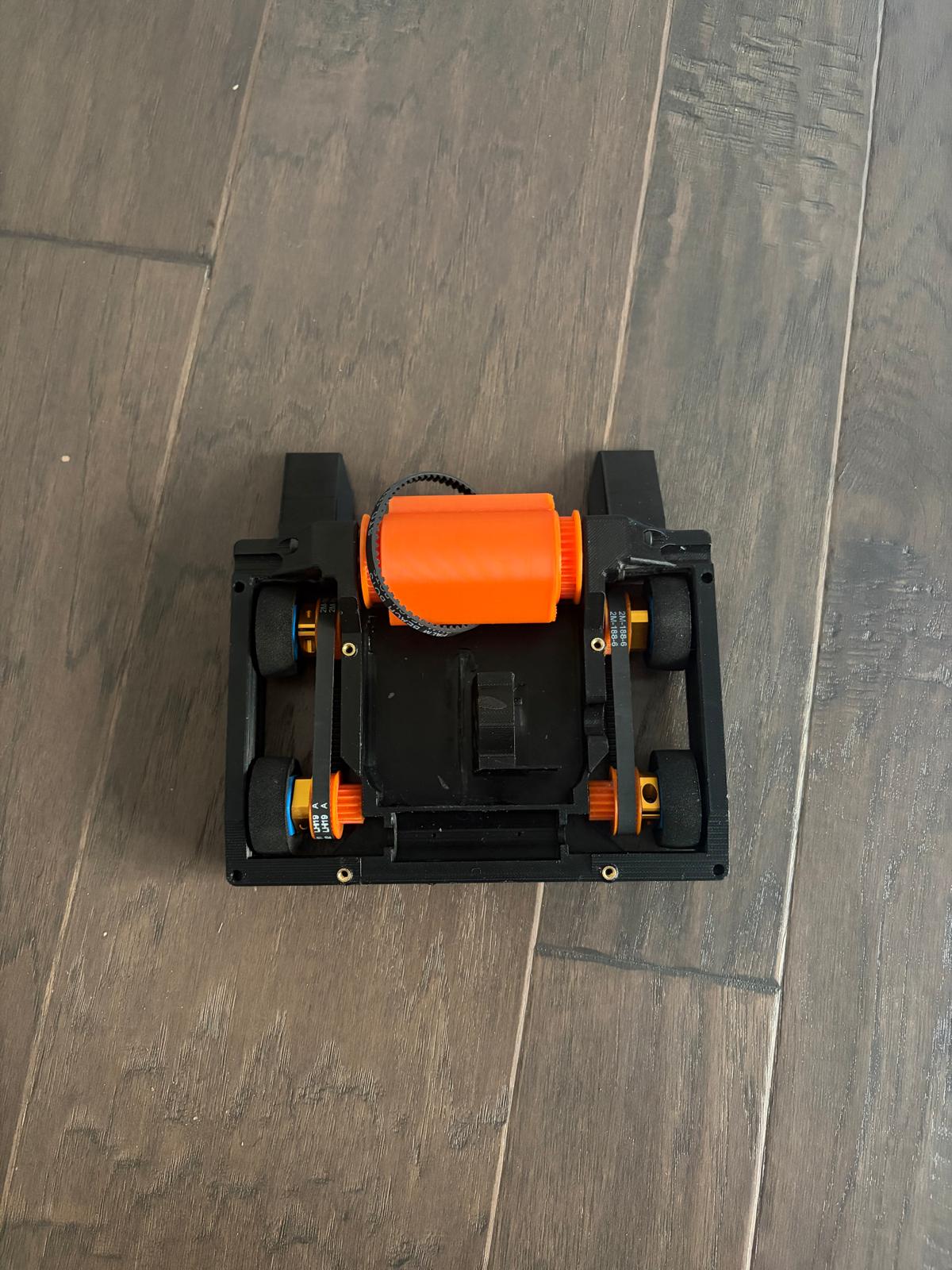 chassis top down with no electronics: drum, belt loop, four wheels, empty centre motor mount